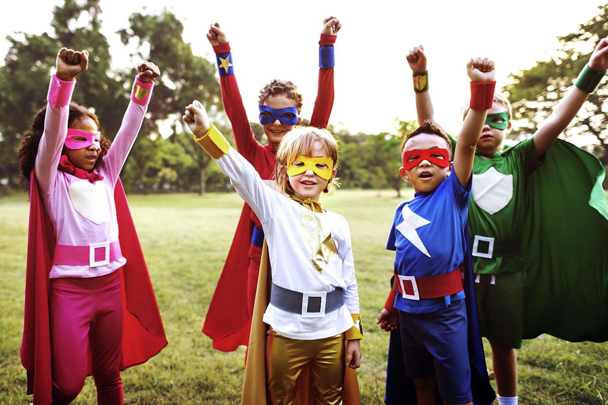 Young children dressed in superhero halloween costumes