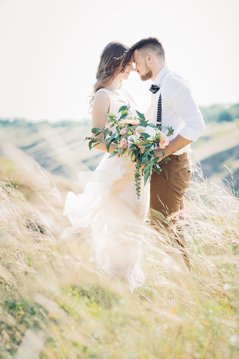 Bride and groom hugging at the wedding in grass field