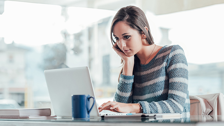 The figure shows a woman working on her laptop.